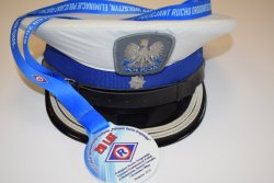 Czapka służbowa podinspektora Policji, obok niej okolicznościowy medal z okazji 20-lecia konkursów &quot;Policjant Ruchu Drogowego&quot;